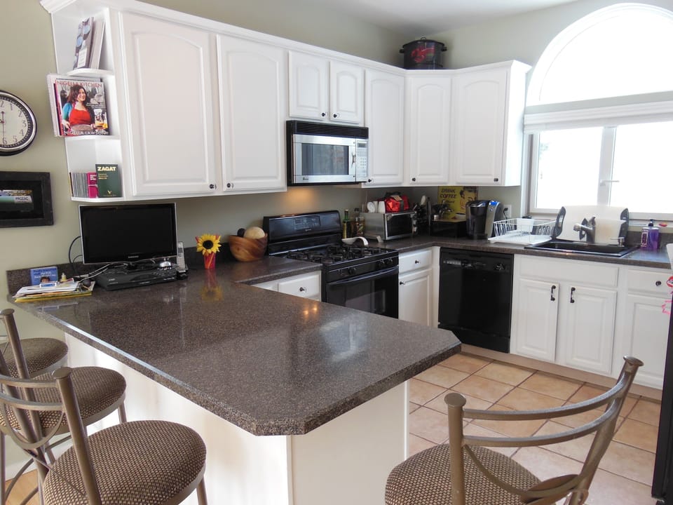 Kitchen with range, dishwasher, microwave, TV