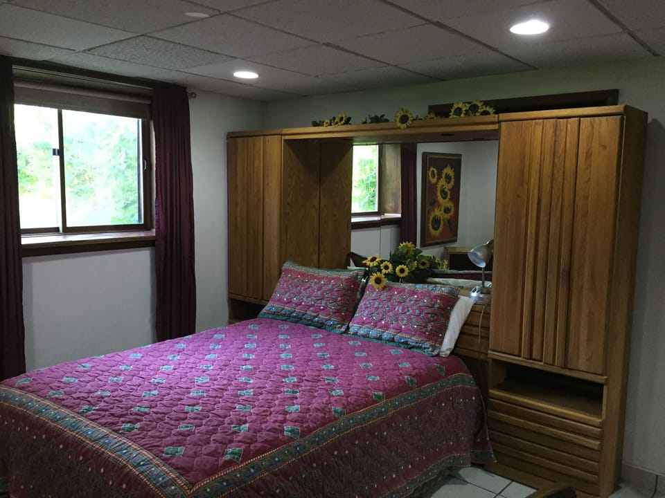 Queen bed with view of the back  yard, a large closet, and flatscreen HDTV, and 