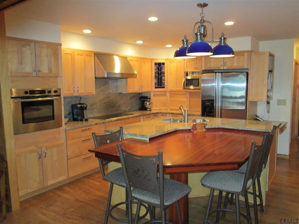 gourmet kitchen with custom table and chairs.  Also full dining table adjacent
