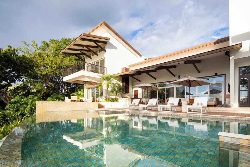 Luxurious swimming pool at Villa Belvedere with comfortable outdoor furniture and lush green surroundings