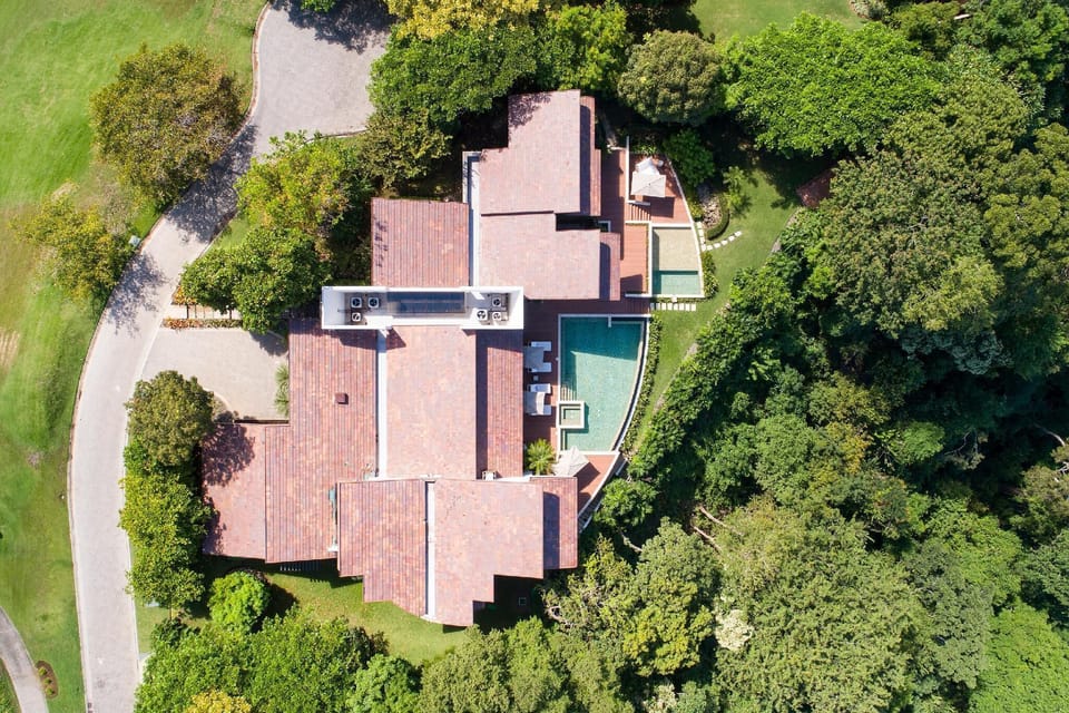 Enchanting allure of Villa Belvedere from above, with an aerial view showcasing the villa nestled amidst a verdant landscape of trees