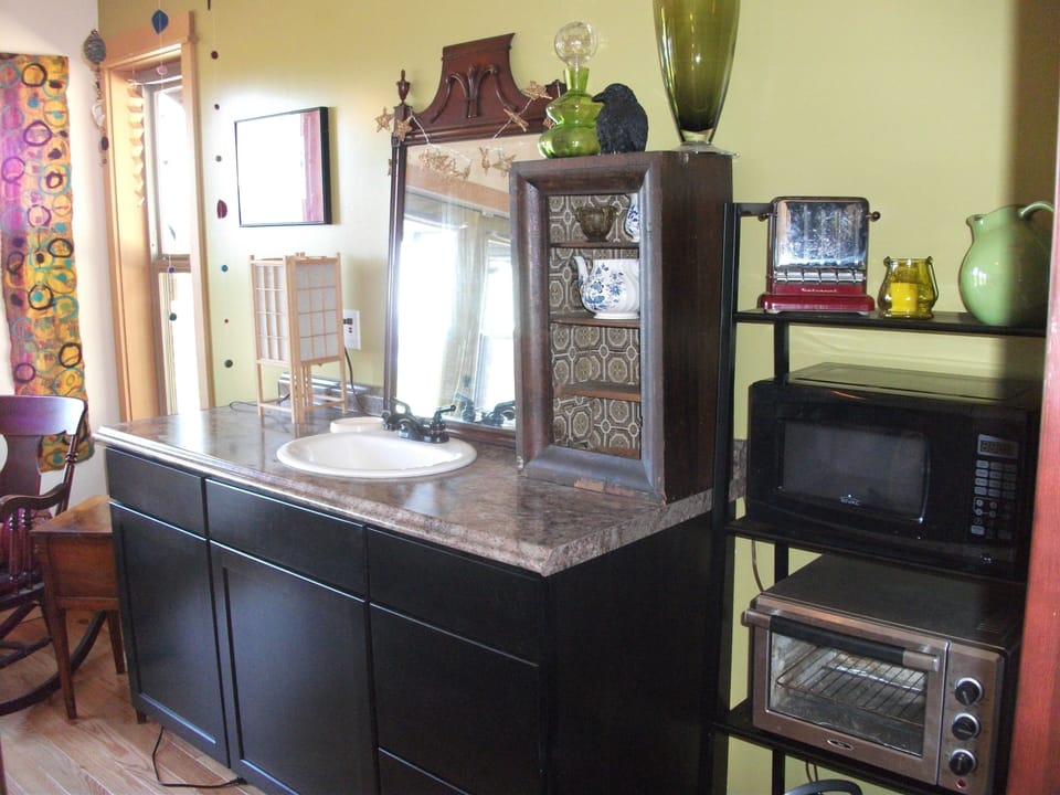 Mini Kitchen with microwave, fridge in left cabinet, convection oven, sink, etc.