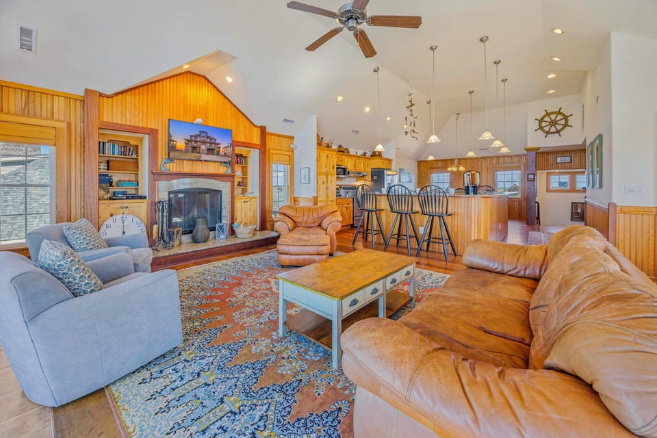Relax in your spacious living room with nautical charm, where leather sofas and a cozy fireplace create the perfect gathering space.