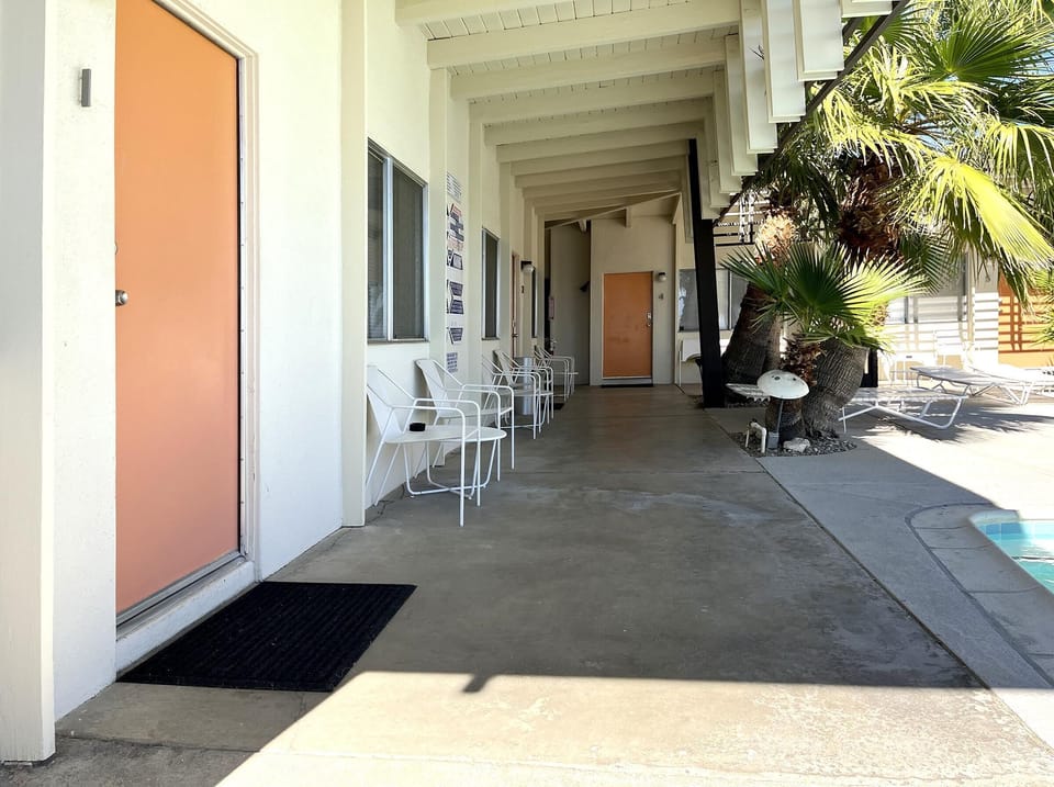 Shaded poolside walkways with patio tables and chairs