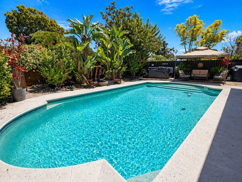 Relax by your private pool in a lush, tropical backyard