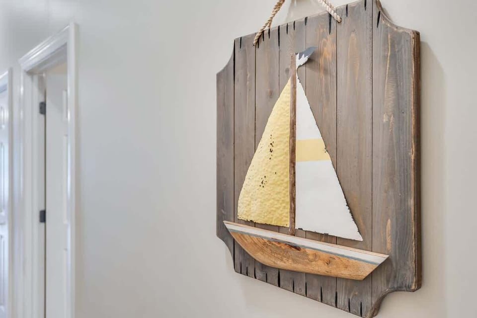 - Nautical charm greets you at every turn, starting with this handcrafted sailboat wall art - Coastal textures and warm wood tones add beachy character to the hallway - Just a small detail, but one that sets the vacation mood instantly