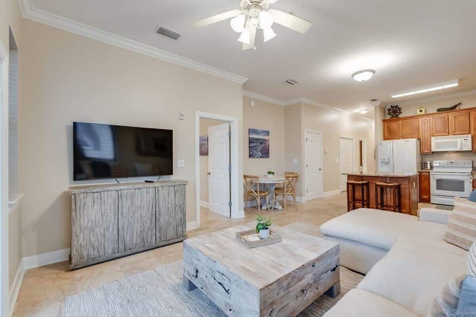 - Spacious living area with an open layout connecting the kitchen, and dining seamlessly - Comfy sectional, coastal hues, and mounted TV make it perfect for relaxing - Island seating, granite counters, and beachy vibes invite conversation