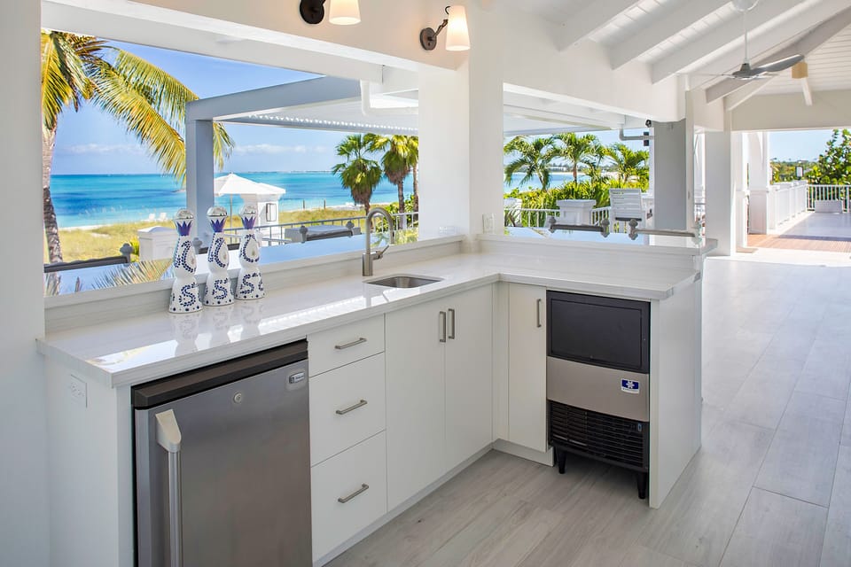 Outdoor bar and grill with refrigerator and separate ice maker.