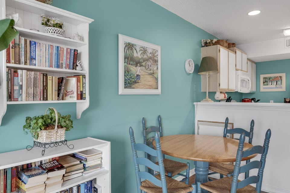 A cozy dining space with a shelf of books for rainy days.