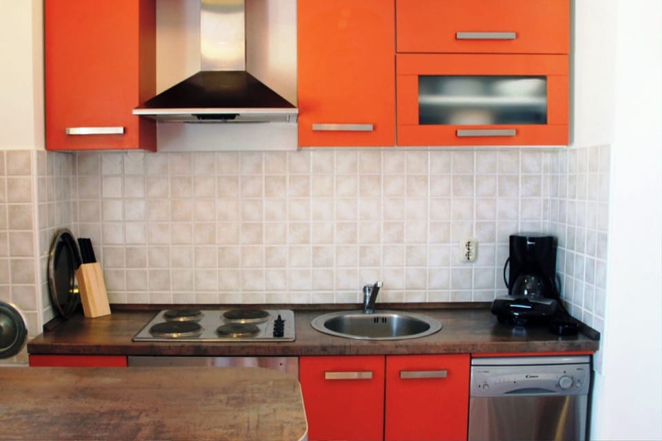 The kitchen is fully equipped with a stove, dishwasher, fridge-freezer, and cooking utensils.