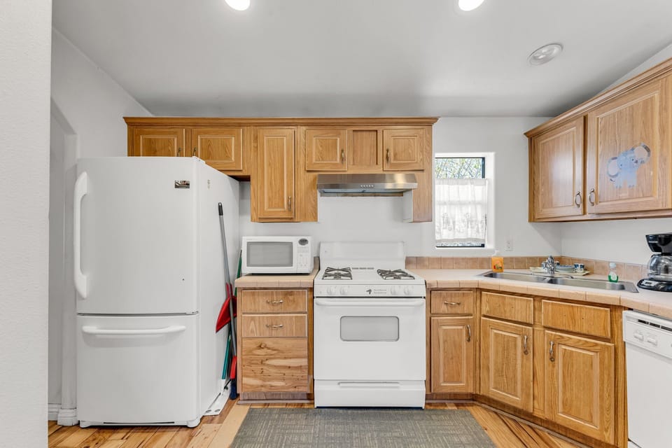 The kitchen is equipped with a stove, microwave, coffee machine, and dishwasher
