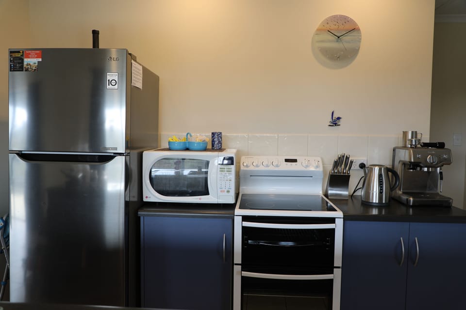 Kitchen appliances including microwave, new stove and espresso coffee machine