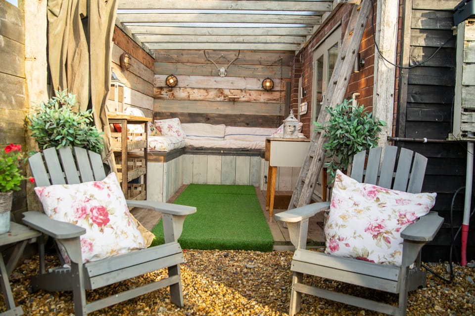 Relax in the under cover outdoor area of The Cowshed and BBQ in the private garden