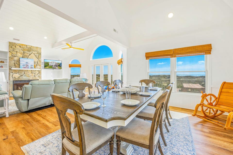 Gather around this elegant dining table while taking in sweeping landscape views through floor-to-ceiling windows in this bright, open living space.