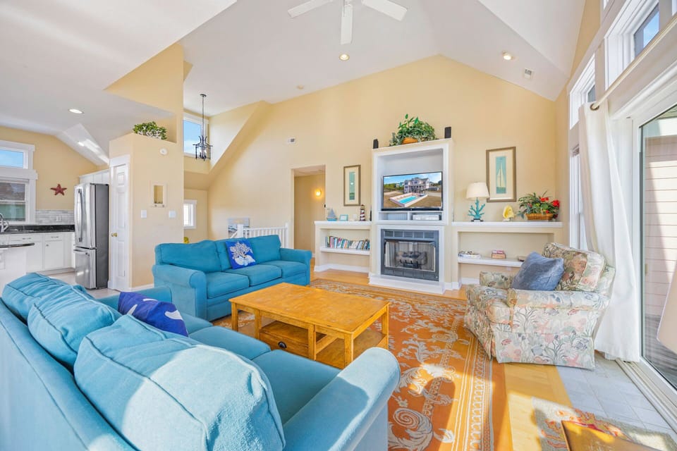 Relax in this airy living space with soaring ceilings, cozy fireplace, and plush seating perfect for gathering with family.