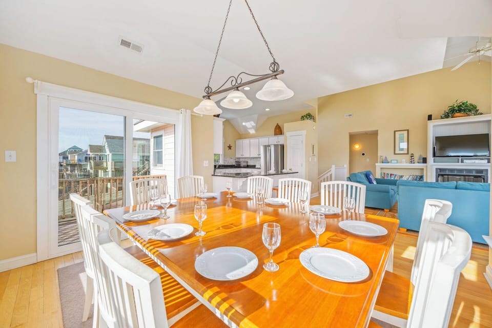Your spacious dining room welcomes memorable meals with elegant table settings and warm natural light streaming through patio doors.