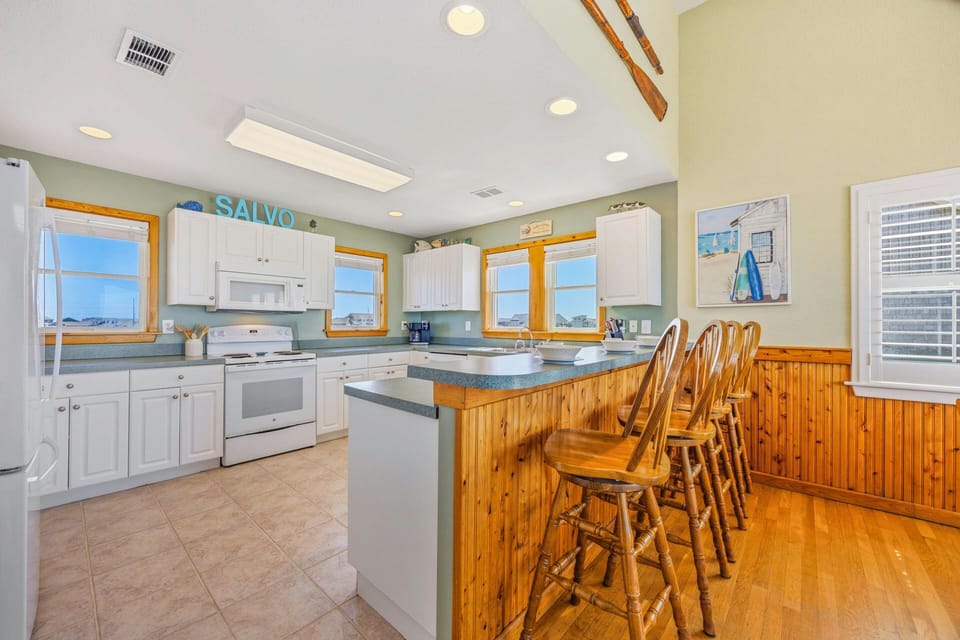 Your spacious kitchen welcomes you with white cabinets, modern appliances, and a breakfast bar perfect for morning coffee with stunning views.