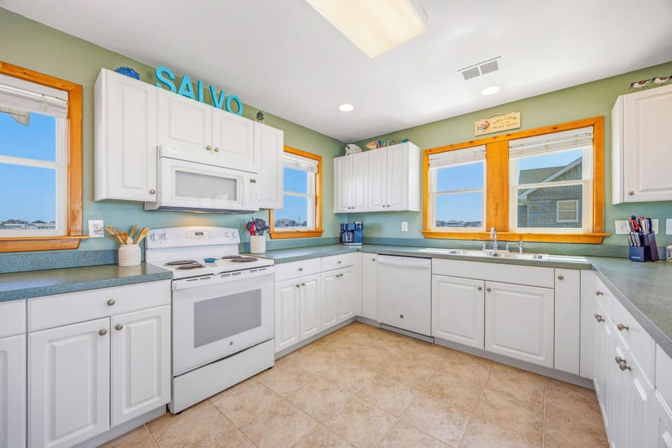 Your spacious kitchen awaits with white cabinets, modern appliances, and plenty of counter space for cooking memorable meals during your stay.