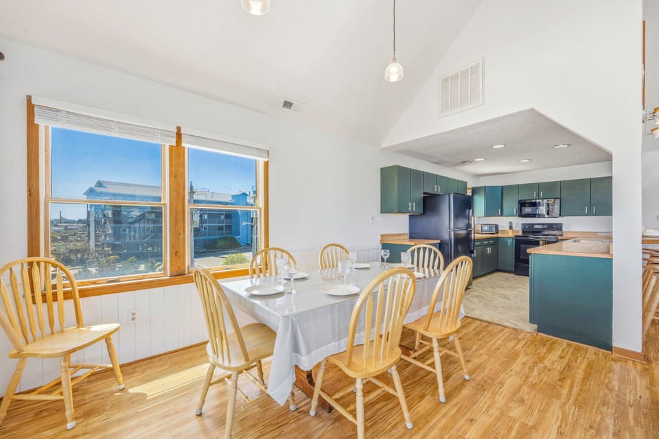 Gather around your spacious dining table with panoramic windows framing stunning views while the modern kitchen awaits your culinary adventures.