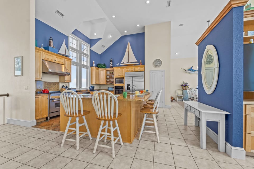 The kitchen's breakfast counter is well within conversation range of the multiple dining tables.