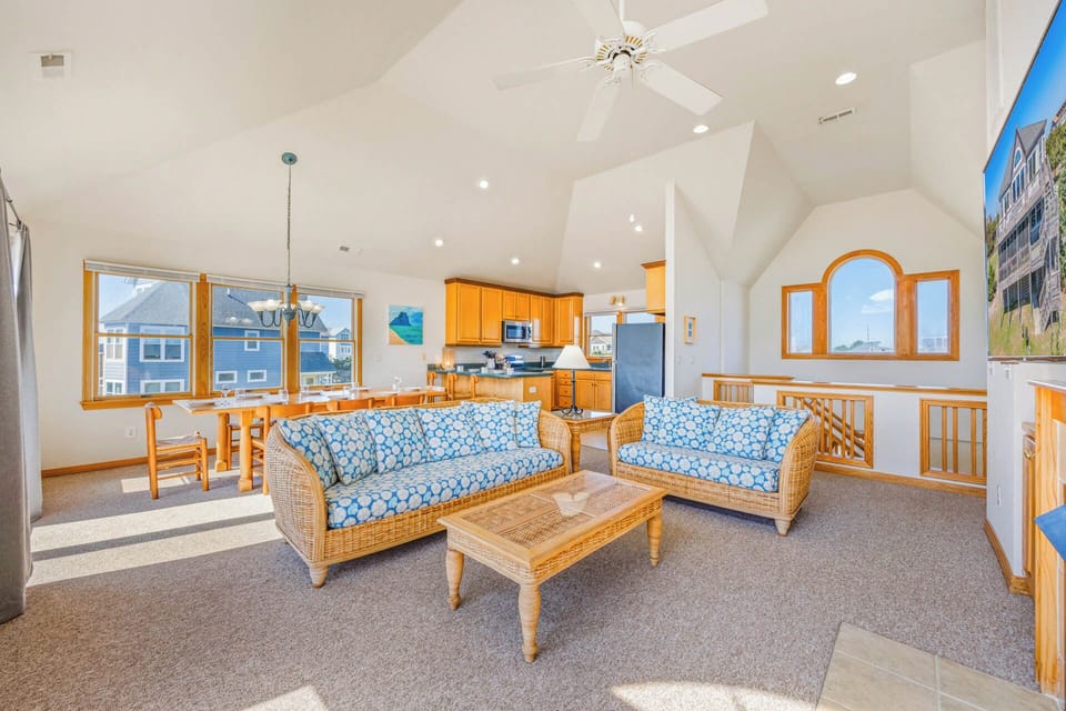 Your bright, airy retreat features vaulted ceilings, cozy coastal furnishings, and a fully-equipped kitchen opening to a sunny living space—perfect for relaxed gatherings after beach days.
