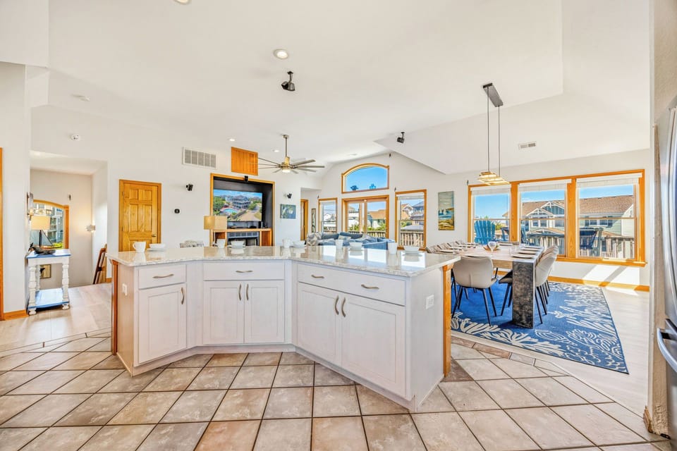 Step into your light-filled open-concept space where cooking and gathering flow effortlessly together—high ceilings and natural light wrap around you as you prepare meals and make memories with everyone close by.