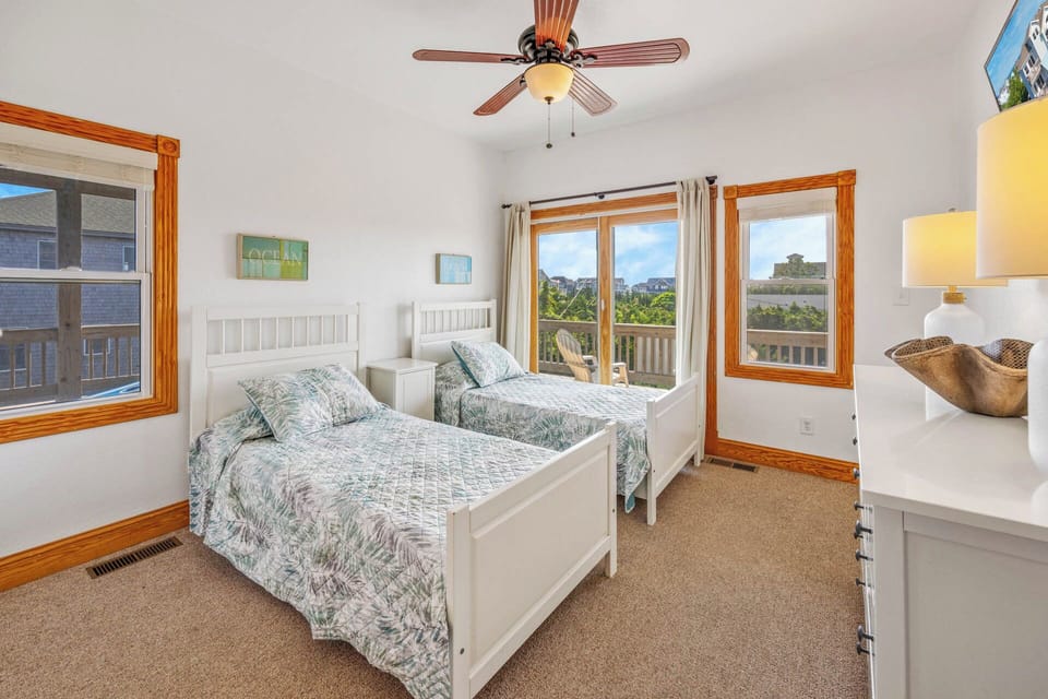 The second level twin bedroom includes 2 single beds, private access to the deck, and shares the full hall bath.