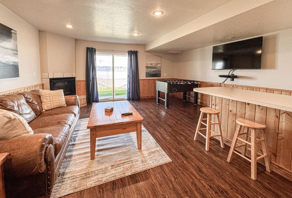 Cozy entertainment room with foosball, fireplace, and lake view—perfect for relaxing and fun gatherings.