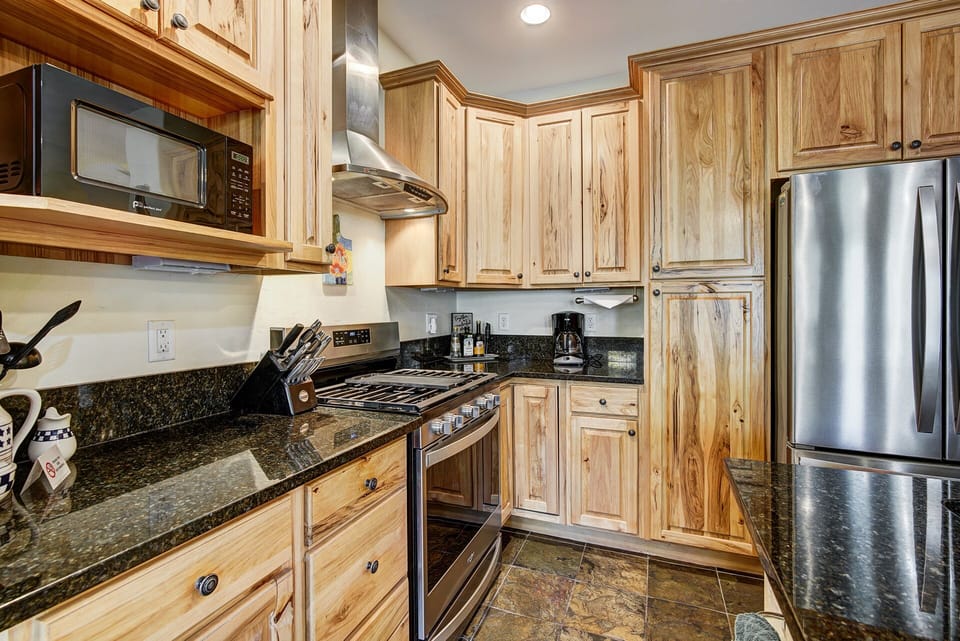 Kitchen with complete kitchenwares, refrigerator, microwave and more.
