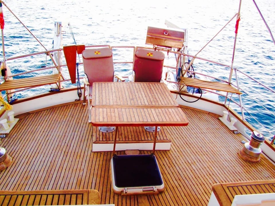 Large teak deck with table & 6 benches.