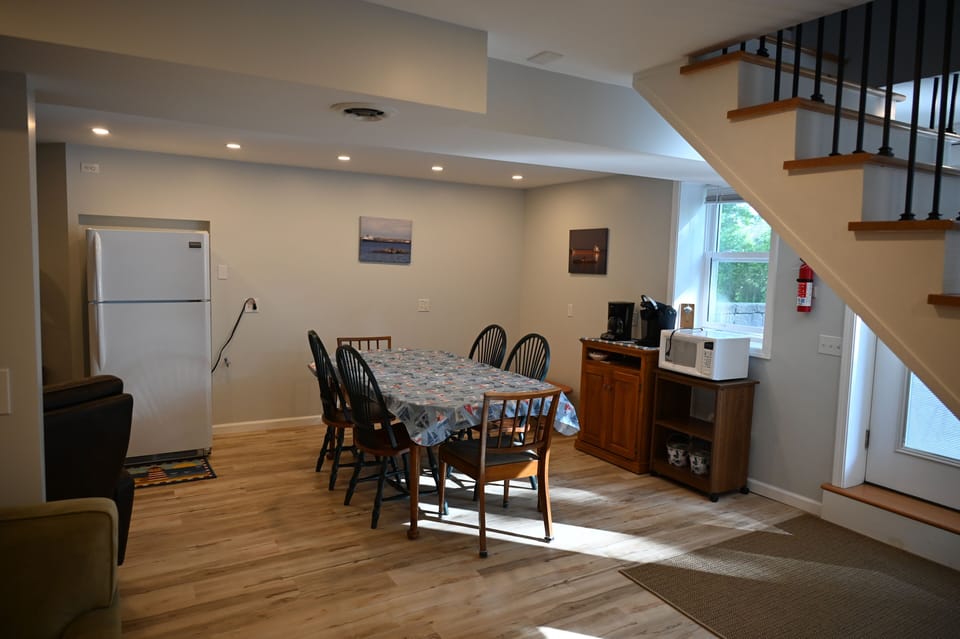 Lower kitchen area with frig, microwave, coffee maker, Keurig, and dining table