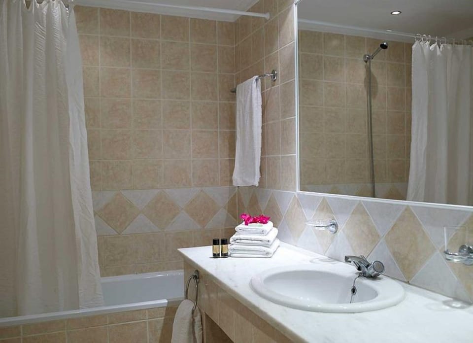 Bathtub, hair dryer, slippers, towels