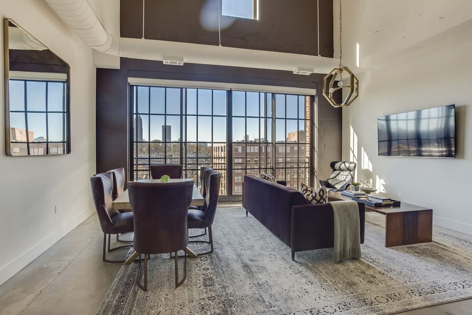 Living and Dining area with a sofa facing a wall-mounted TV and a dining table with seating for 6.