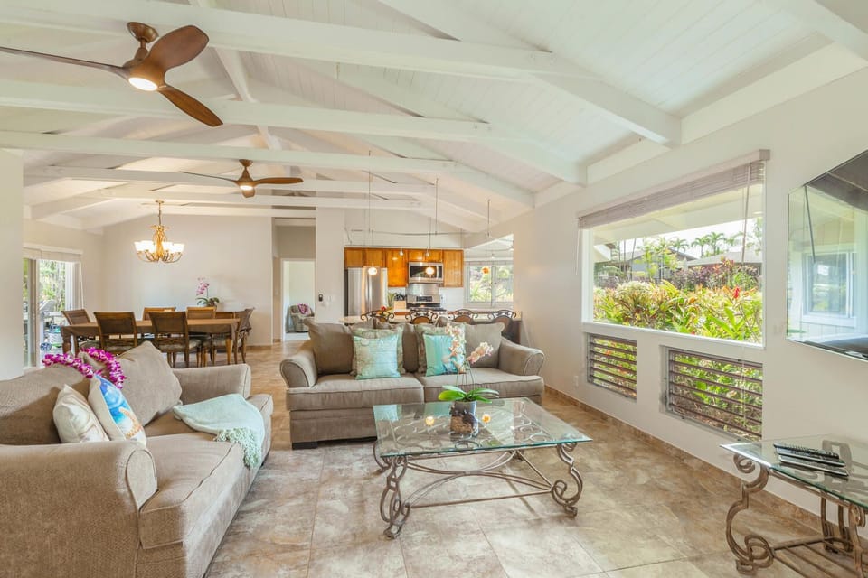 Open-concept living at Mala Hale with vaulted ceilings, plush sofas, and garden views