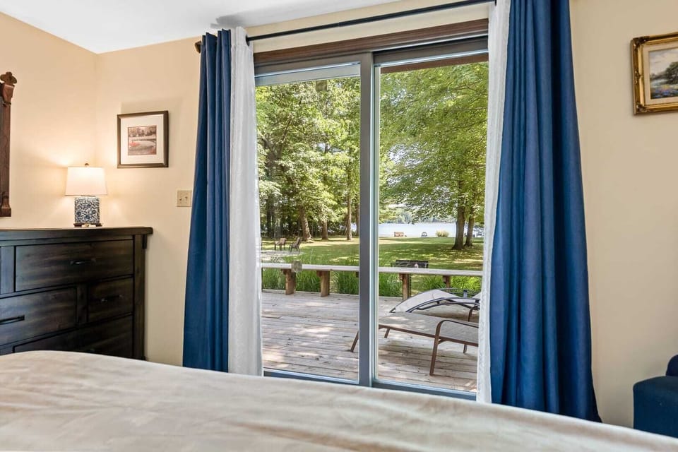 Bedroom # 1: Come and take in the amazing lake views through the sliding glass door of the main floor king bedroom of the Upper Scott Lake Retreat - with one (1) king bed, closet, dresser & patio door exit to our lake-facing deck.
