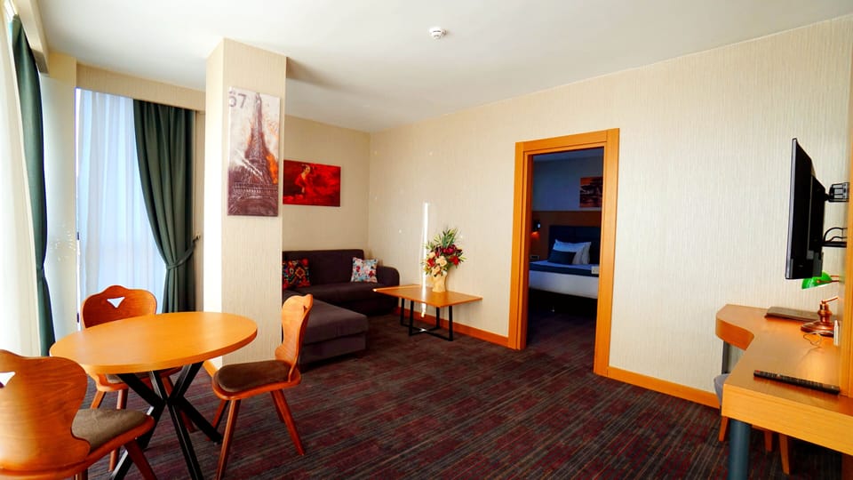 Deluxe Suite, City View | Minibar, in-room safe, desk, blackout drapes