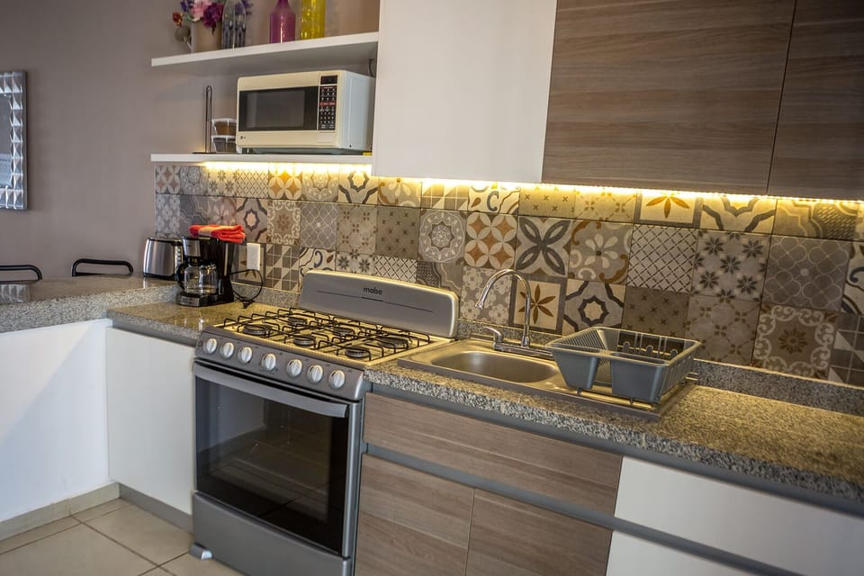 Fully equipped gourmet kitchen with gas stove, oven, grill and coffee maker.