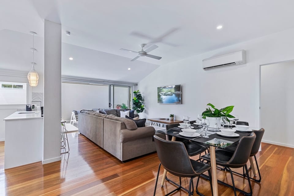 Bright open-plan living room with Samsung 50" 4K and a rollaway bed.
