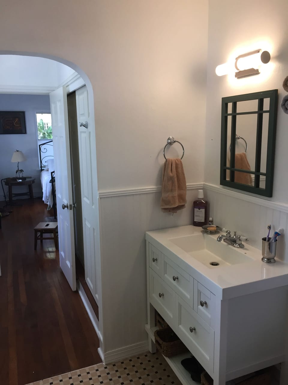Bathroom sink, soaps, shampoo, conditioner and more in baskets.