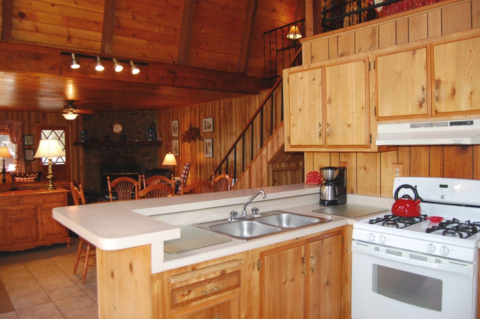 Reverse angle of kitchen with dining table and living room in background