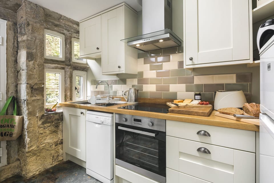 The exposed stone wall and mullioned window in the kitchen date from about 1650