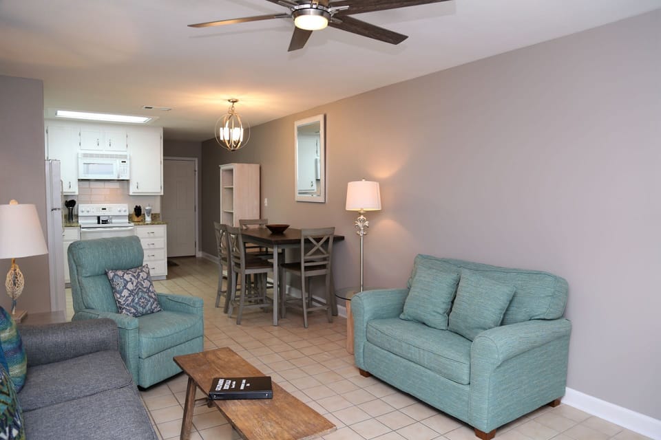 The updated living room includes a large, Smart TV, ample seating, and direct access to the private balcony.