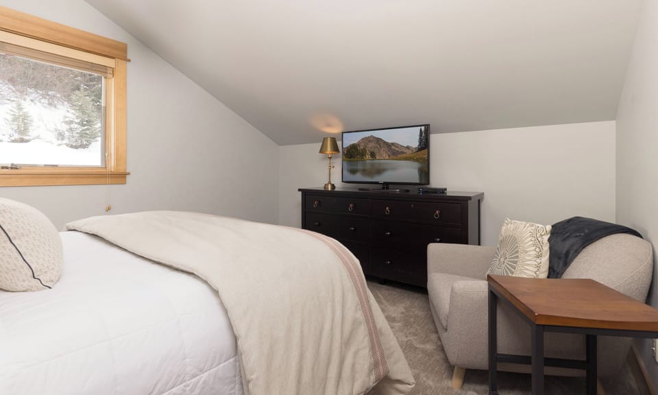 Unwind in your cozy bedroom retreat with plush bedding, comfortable seating, and mountain views from your window.