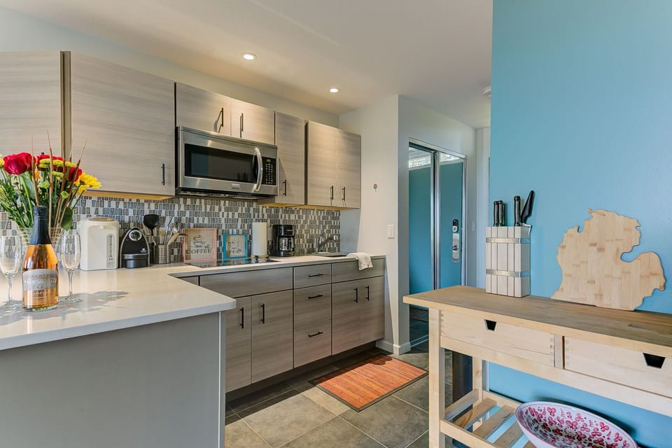 A full kitchen, excluding an oven and dishwasher, is equipped with essential amenities such as a coffee maker, stove top, microwave, toaster, pots and pans, tea towels, cooking utensils, silverware, and more for your culinary convenience.