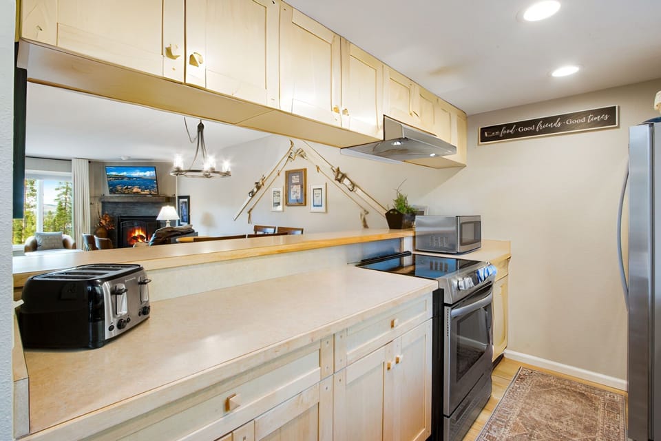 Sunny Galley Kitchen has modern appliances. Kitchen is open to dining area.