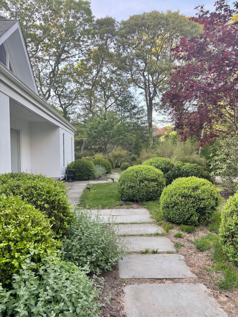 Mature landscaping on 1 acre property with fencing and front gate.