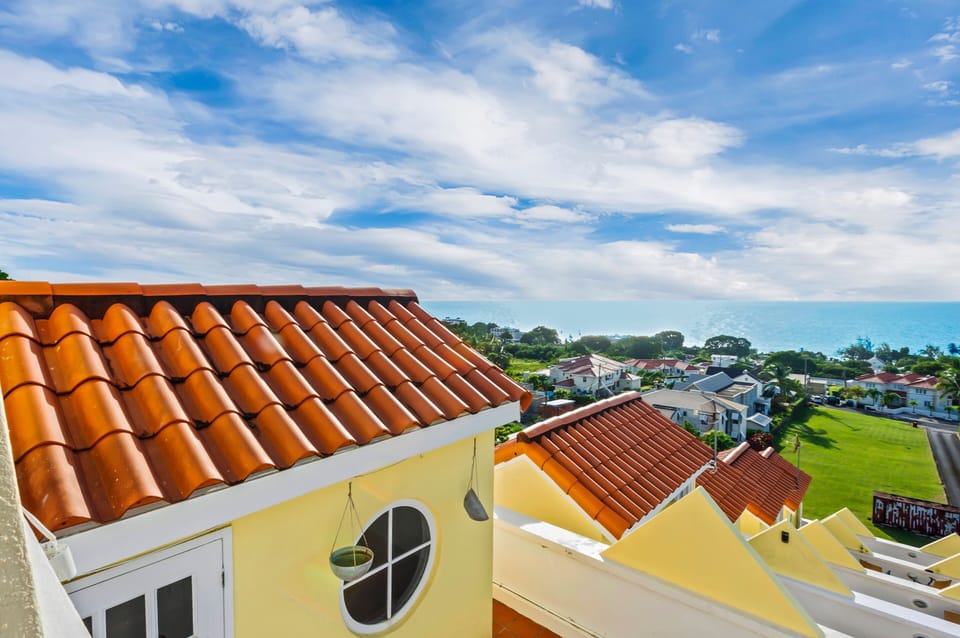 View of the Caribbean sea from our rooftop deck with lounge chairs and tables