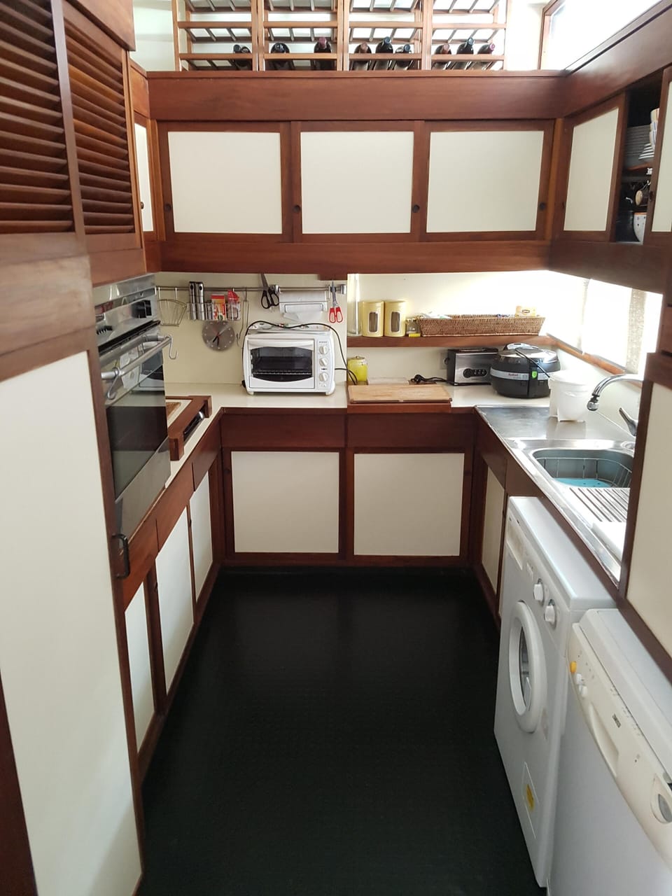 The kitchen with an oven, dishwasher and washing machine