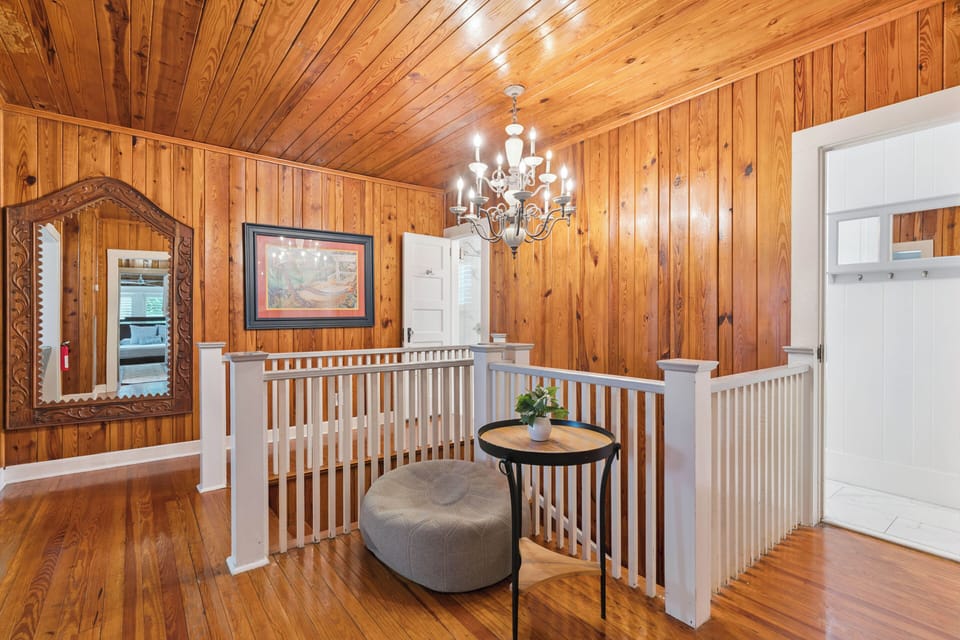 Step into warm, inviting wood-paneled interiors where natural textures meet thoughtful design. A stunning chandelier illuminates your path through open, connected spaces that make this home feel both elegant and welcoming.