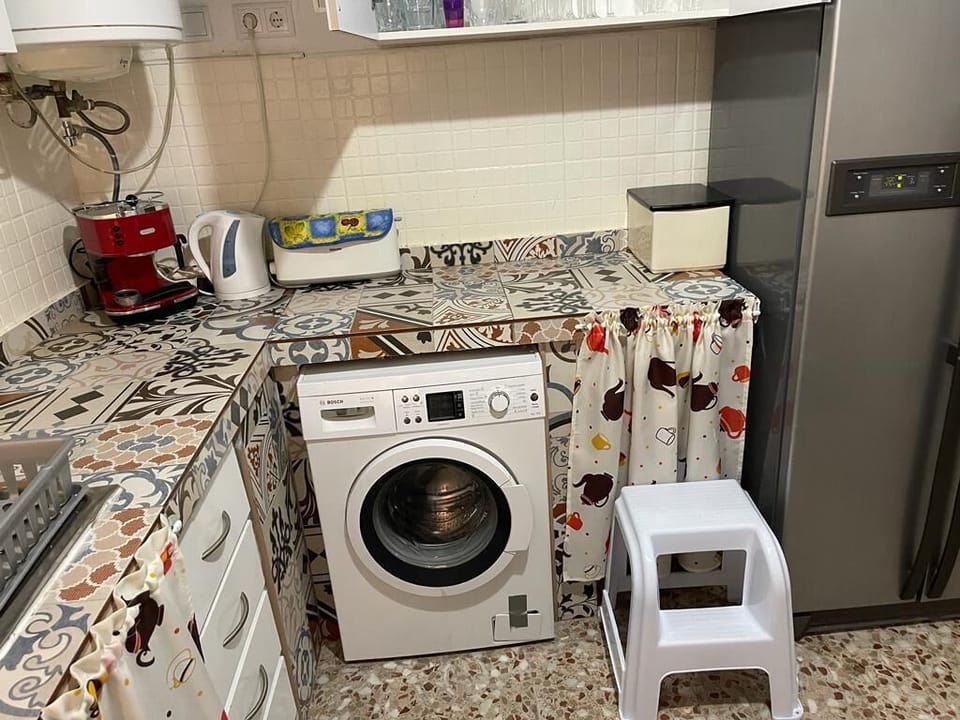 kitchen with large fridge freezer, washing machine, utensils and equipment